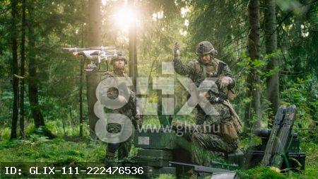 In the Military Staging Base Army Engineer and Soldiers Operate Military Grade Industrial Drone for their Reconnaisance/ Surveillance Mission/ Operation. Theater of Operation is in Forest Area.
