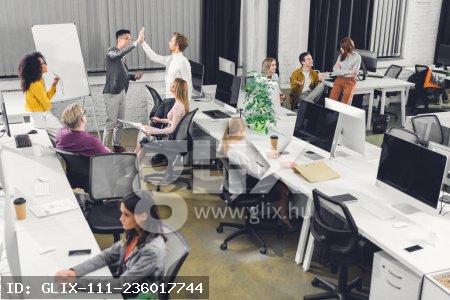 high angle view of professional multiracial businesspeople working together in open space office