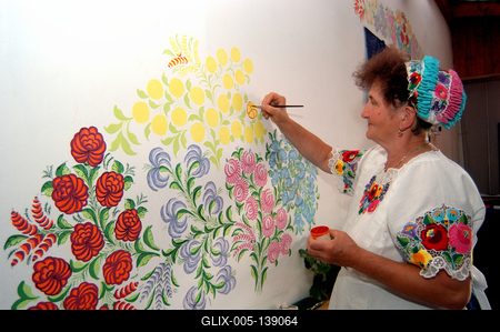 Kalocsai népviseletbe öltözött asszonyok falat pingálnak-stock-foto