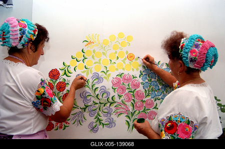 Kalocsai népviseletbe öltözött asszonyok falat pingálnak-stock-foto