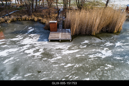 Aerial view of winter frozen lake with wooden houses on pier-stock-foto
