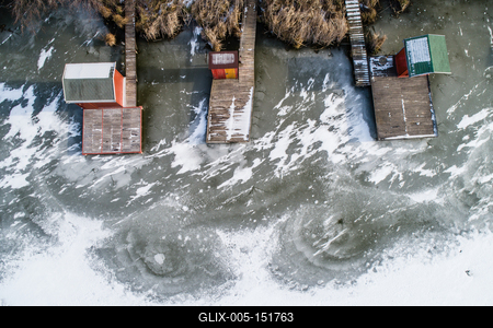 Aerial view of winter frozen lake with wooden houses on pier-stock-foto