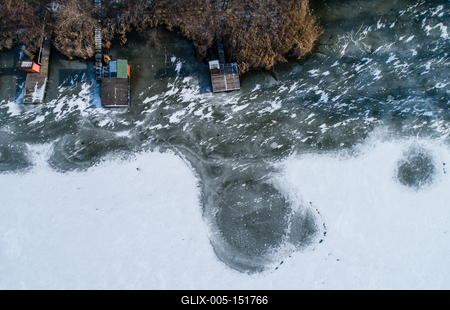 Aerial view of winter frozen lake with wooden houses on pier-stock-foto