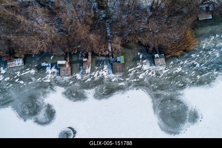 Aerial view of winter frozen lake with wooden houses on pier-stock-foto