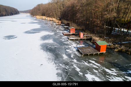 Aerial view of winter frozen lake with wooden houses on pier-stock-foto
