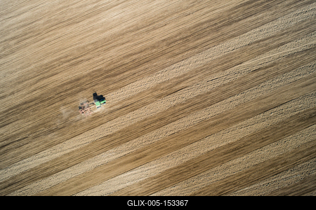 Aerial view of tractor plowing farm field in preparation for spring planting-stock-foto