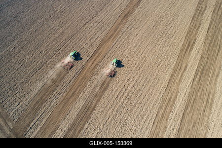 Aerial view of tractor plowing farm field in preparation for spring planting-stock-foto