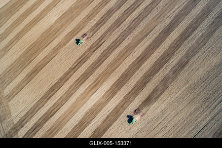 Aerial view of tractor plowing farm field in preparation for spring planting-stock-foto