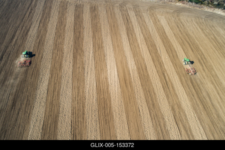 Aerial view of tractor plowing farm field in preparation for spring planting-stock-foto