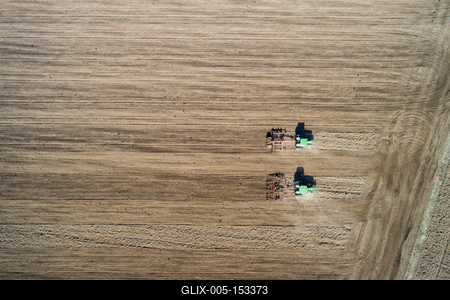 Aerial view of tractor plowing farm field in preparation for spring planting-stock-foto