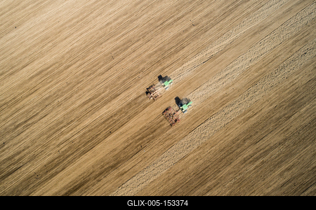 Aerial view of tractor plowing farm field in preparation for spring planting-stock-foto