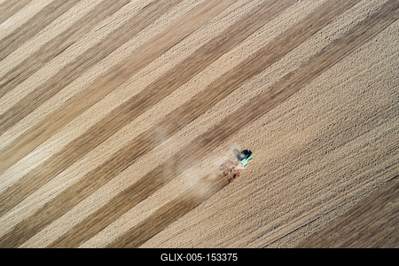 Aerial view of tractor plowing farm field in preparation for spring planting-stock-foto