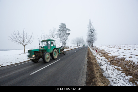 Fast moving tractor with snowy road-stock-foto