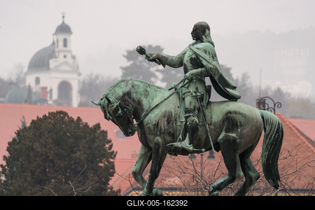 statue of Janos Hunyadi on Szechenyi Square in Pecs, Hungary with chapel at background-stock-foto