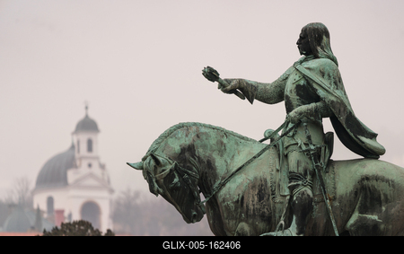 statue of Janos Hunyadi on Szechenyi Square in Pecs, Hungary with chapel at background-stock-foto