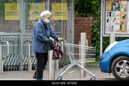 PECS - MAY 27 : Old woman go to shopping on the street  on 27 May 2020 in Pecs, Hungary. During coronavirus pandemic, everybody have to waering face mask-stock-foto