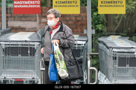 PECS - MAY 27 : Old woman go to shopping on the street  on 27 May 2020 in Pecs, Hungary. During coronavirus pandemic, everybody have to waering face mask-stock-foto