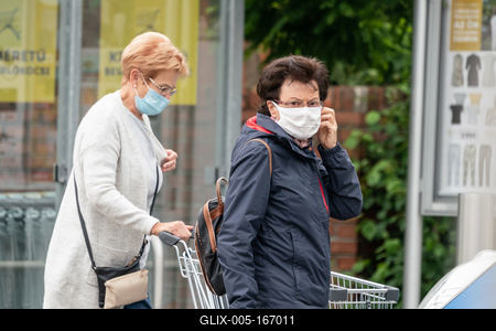 PECS - MAY 27 : Old woman go to shopping on the street  on 27 May 2020 in Pecs, Hungary. During coronavirus pandemic, everybody have to waering face mask-stock-foto