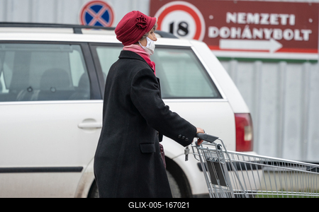 PECS - MAY 27 : Old woman go to shopping on the street  on 27 May 2020 in Pecs, Hungary. During coronavirus pandemic, everybody have to waering face mask-stock-foto