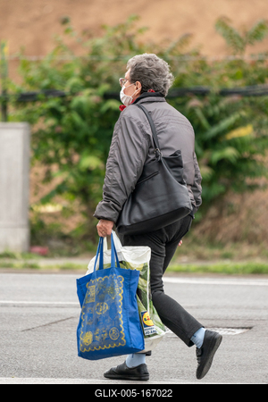 PECS - MAY 27 : Old woman go to shopping on the street  on 27 May 2020 in Pecs, Hungary. During coronavirus pandemic, everybody have to waering face mask-stock-foto
