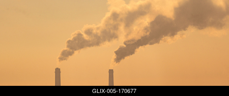 Smoking factory chimneys in morning backlit by rising sun-stock-foto
