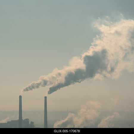 Smoking factory chimneys in morning backlit by rising sun-stock-foto
