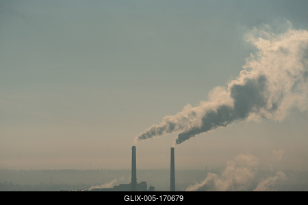 Smoking factory chimneys in morning backlit by rising sun-stock-foto