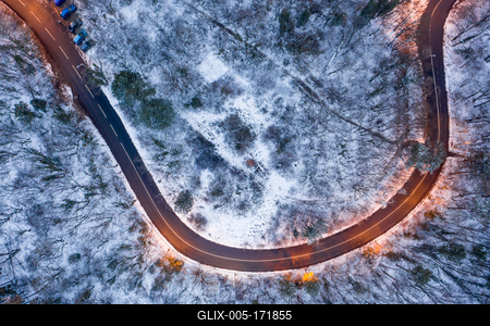 aerial view of curvy road with snowy forest-stock-foto