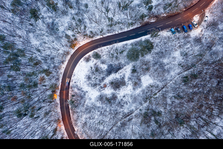 aerial view of curvy road with snowy forest-stock-foto