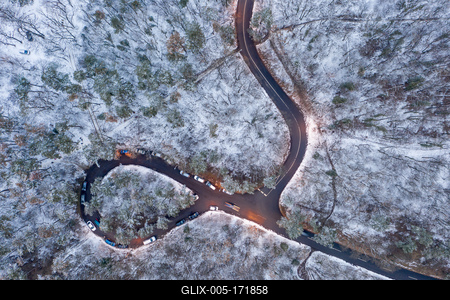 aerial view of curvy road with snowy forest-stock-foto