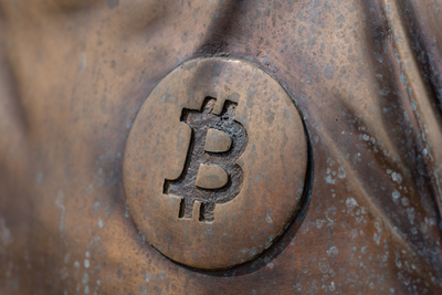 a bitcoin icon on a bronze statue-stock-foto