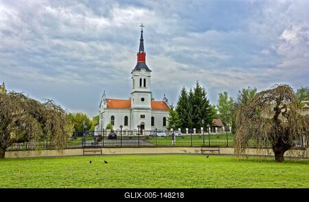 Szécsény, evangelikus templom vas kerítéssel és fűz fákkal-stock-foto