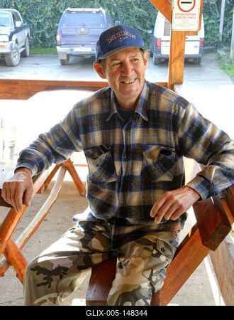 Igazi szatmári ember, mosolygós férfi űl egy padon, Panyolában-stock-foto