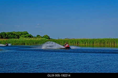 Tisza-tó Sarudnál két jet-ski vezetõ a zöld nádas elõtt száguldanak-stock-foto