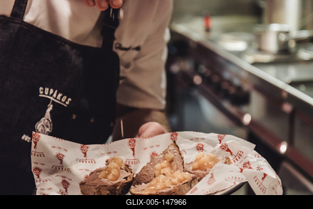 Szakács az elkészült étellel, konyhában, a bulinegyedben-stock-foto