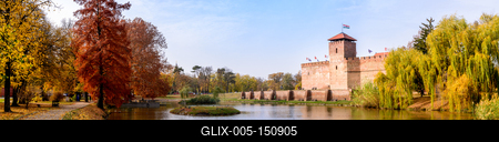 The only remaining brick-built medieval fortress. In front of the castle is a boating lake and a huge willow tree in autumn. Panorama view, Hungary, Gyula-stock-foto