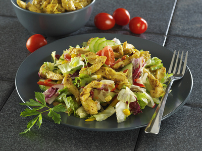 Currys-mustáros csirkecsíkok, tavaszi salátaágyon-stock-foto