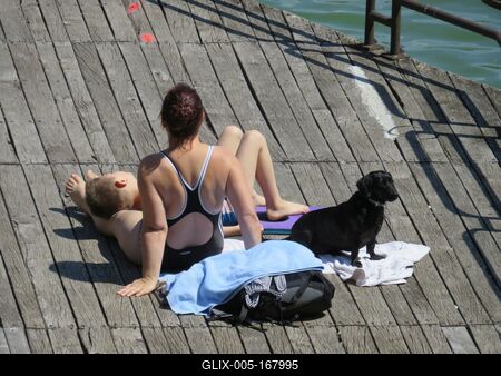 Bánk, 13 May 2018Sunbathing mother with Son and Dog at the Lake of Bánk (Northern Hungary).Napozó anya kisfiával és kutyával a Bánki-tónál.-stock-foto