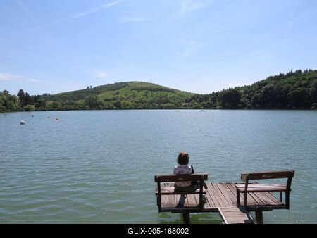 Bánk, 13 May 2018Woman seating on a Pier at the Lake of Bánk (Northern Hungary).Stégen ülõ hölgy a Bánki-tavon.-stock-foto