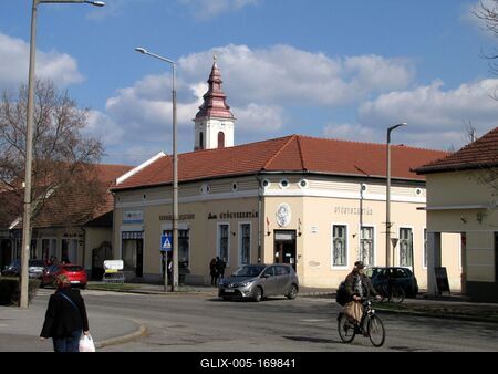 Sárospatak, 2016. március 16.Biciklizõ férfi és gyalogos nõ a Rákóczi úton, a Kossuth Lajos utca keresztezõdésében. Háttérben a református templom tornya.-stock-foto