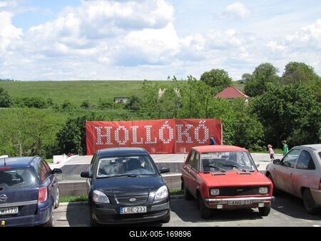 Hollókõ, 2016. május 16.Gyerekek játszadoznak a Hollókõ nevét feltüntetõ óriás molinó elõtt, parkoló gépkocsik társaságában Hollókõn Pünkösd hétfõn.-stock-foto