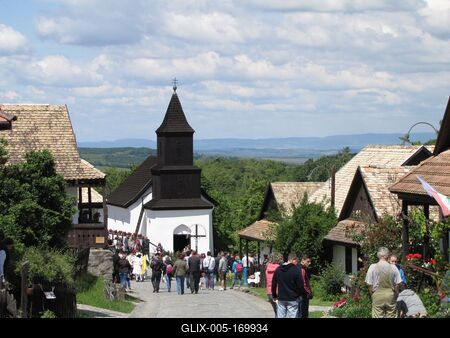 Hollókõ, 2016. május 16.Pünkösdi hangulat a hollókõi ófalu fõutcájában. Szemközt a világörökség részét képezõ ófalu Tours-i Szent Mártonról elnevezett temploma. A fából és vályogból készült kicsiny fatornyos római katolikus templomot 1889-ben közadakozásból építtette a falu lakossága.-stock-foto