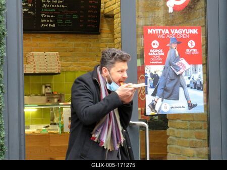 Man bateing pizza with stripped mask - Coronavirus-stock-foto