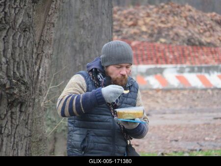 Poor man eating freely distributed food - Budapest-stock-foto