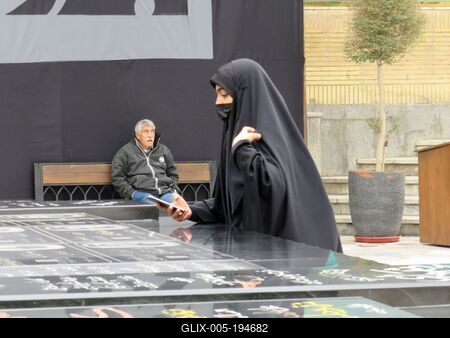 Woman wearing hijab photogtaphing Iranian nuclear physicists' graves - Tehran-stock-foto