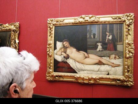 A tourist admires a painting by Tiziano Vecellio - Venus of Urbino - Uffizi Gallery - Florence-stock-foto
