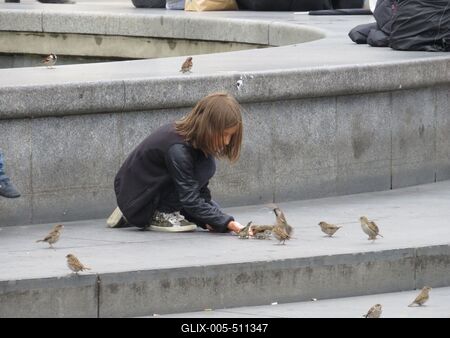 Berlin, 30 June 2017Sparrow feeding little girl at Alexanderplatz fountain.Verebet etet? kisl?ny az Alexanderplatz sz?k?k?tj?n?l.-stock-foto