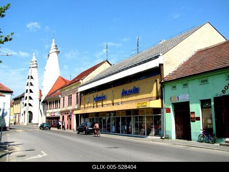 Szigetv?r, 2009. j?nius 15.A szigetv?ri f? ?t, a J?zsef Attila utca Makovecz Imre tervezte (1985) Vigad? Kultur?lis K?zpont toronykapuival, tov?bb? ?zletekkel, lak?h?zakkal.-stock-foto