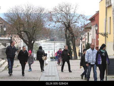 V?c, 2016. m?rcius 27.S?t?l? emberek a v?ci Duna partra vezet? utc?ban. Szemben, a tuls? parton a Szentendrei-sziget l?that?.-stock-foto