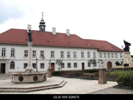 V?c, 2016. m?rcius 27.Az irgalmas k?h?z a M?rcius 15. t?ren. A m?eml?k ?p?let a XVIII. sz-b?l sz?rmazik. A t?ren a Testv?rv?rosi k?t, oszlop?n Evang?lista J?nos szobra. Jobbra az I. vil?gh?bor?s eml?km?.-stock-foto